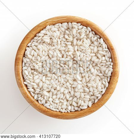 Uncooked Arborio Rice In Wooden Bowl Isolated On White Background With Clipping Path