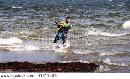 A Young Man Is Engaged In Extreme Kiteboarding In The Gulf Of Riga On October 21, 2020 At Cape Kolka