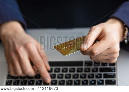 Male Hand Holding Credit Bank Card And Using Laptop. Online Payment, Purchase, Shopping, E-commerce,