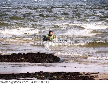 A Young Man Is Engaged In Extreme Kiteboarding In The Gulf Of Riga On October 21, 2020 At Cape Kolka