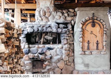 Old Slavic Village Street Cooking Stove With Stack Of Firewood Nearby