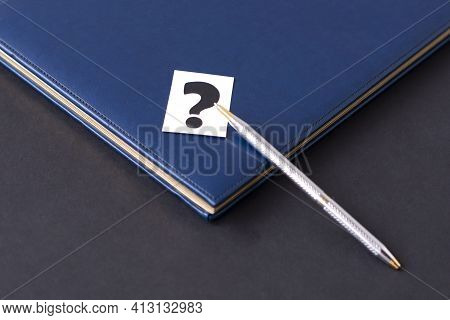 Blue Diary,question Mark And Pen On A Black Background. Planning. Business Concept