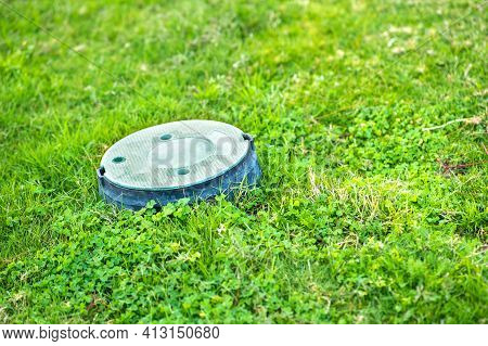 Closeup Of Green Plastic Pipe With Cover On Green Grass Lawn.