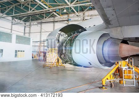 Close-up Repair Of Aircraft Engine On The Wing. White Passenger Airplane Under Maintenance In The Ha