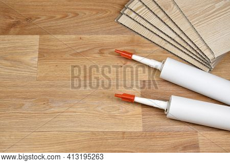 Set Of Items For Pvc Ceiling Indoor Works. Assembly Adhesive Bottles And Pvc Panels. Indoor Vpc Sidi