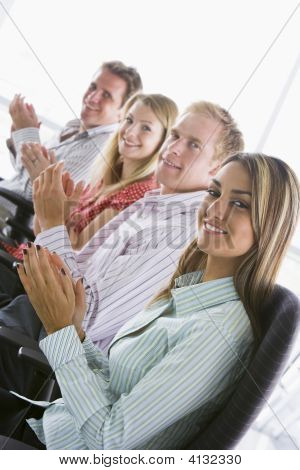 Four Businesspeople Applauding Indoors Smiling