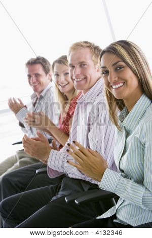 Four Businesspeople Applauding Indoors Smiling