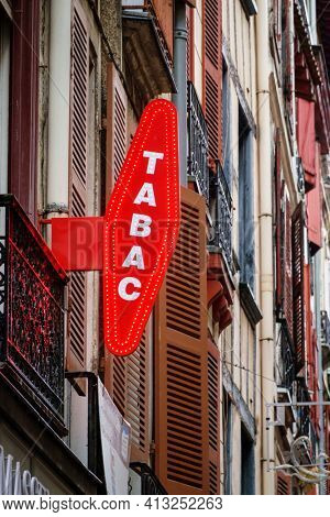 BAYONNE, FRANCE - CIRCA DECEMBER 2020: French red tobacconist sign outside tobacco shop.