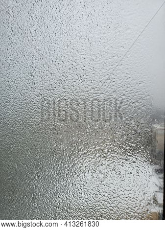 Texture Of Frozen Glass Window In Heavy Cold Weather Outdoors. Blurry Iced Droplets Outside The Wind