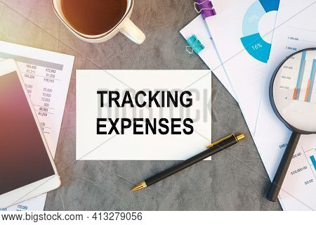 Tracking Expenses Is Written In A Document On The Office Desk With Office Accessories, Smartfon And 