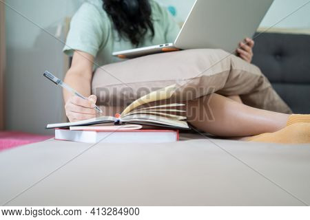 Glasses Beautiful Asian Woman Is Working From Home With Her Laptop And Write A Note Into Notebook Be