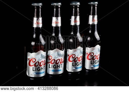 Sandhurst, United Kingdom, 18th March 2021:- Four Bottles Of Coors Light Isoalted On A Black Backgro