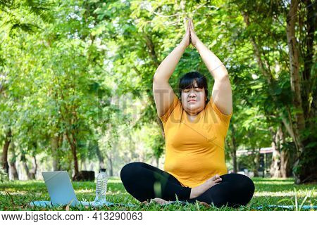 Fat Asian Women Wearing Yellow Tops Exercise In The Park. Sit In Yoga Poses, Practice Meditation, An
