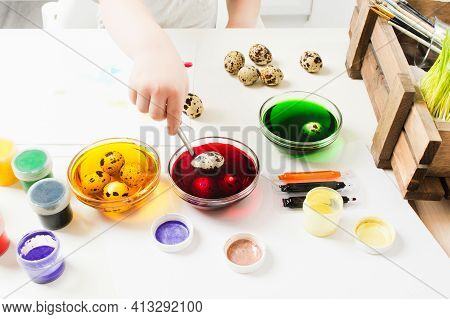 Baby Hand Painted Quial Eggs With Colorful Paints On Table For Easter Holiday