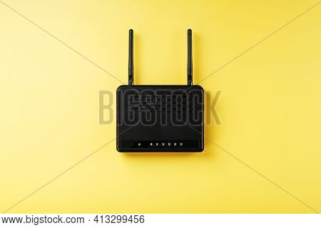 Black Wi-fi Router On A Yellow Background With Free Space.