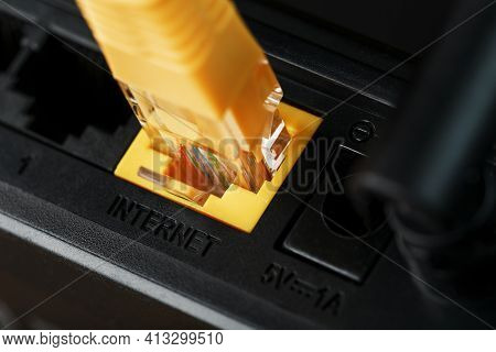 A Yellow Patch Cord Is Inserted Into The Wi-fi Port Of The Router To Access The Internet.