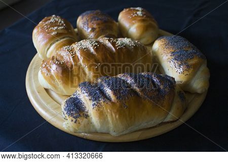 Ruddy Loaves And Buns Made From Wheat Flour With Poppy Seeds And Sesame Seeds On A Wooden Cutting Bo
