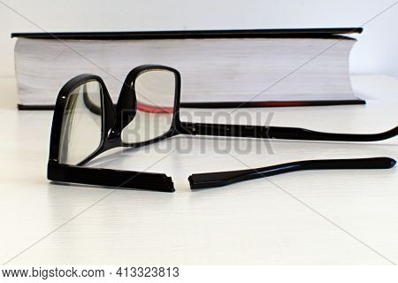 Broken Side Piece Of Glasses Close Up In Foreground And Blurred Background Of Broken Glasses On Whit