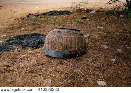 A Borwn Decorated And Painted Burmese Clay Pot Broken And Chipped In The Grass In Bagan, Nyaung-u, M