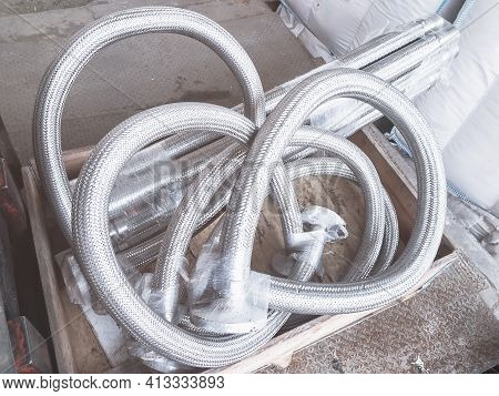 Long Metal Flexible Compensator Pipes Metal Texture Closeup With Lens Flare. Selective Focus. White 