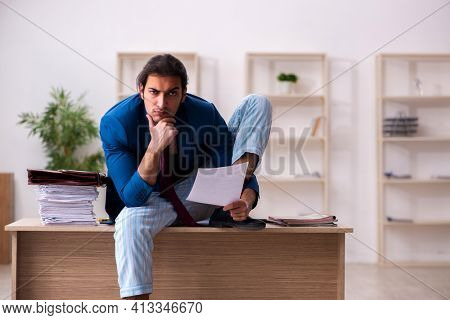 Young male employee in oversleeping concept