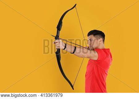 Man With Bow And Arrow Practicing Archery On Yellow Background