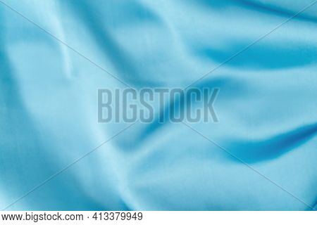 Blue Silk Fabric Defocused For Background. Abstract Blur Satin Fabric. Elegant Sky Color Background 