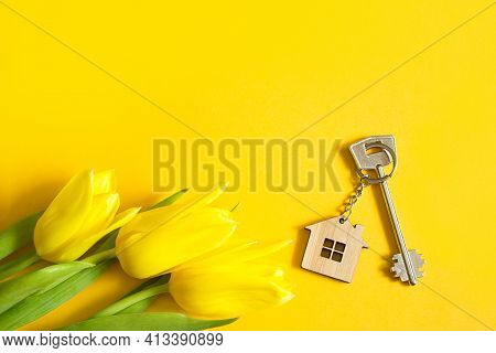 Key Ring In The Shape Of Wooden House With Key On Yellow Background And Spring Tulips. Building, Des