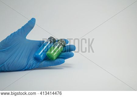 Two Bottles With Injection Lying In The Hand Of A Nurse Isolated On White Background