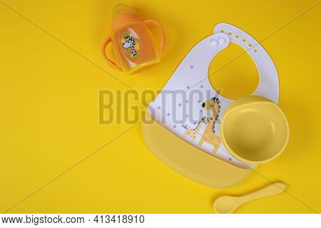 Baby Accessories On Light Yellow Background, Flat Lay. Composition With Space For Text. Baby Bib, A