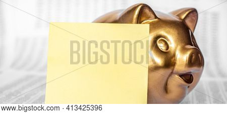 Golden Pig Saving Bank And Yellow Paper For Your Text On Wooden Table With Many Page Financial State