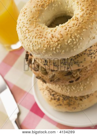 Stakken af seedede Bagels med et glas appelsinjuice