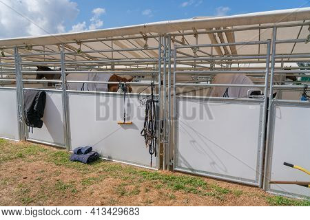 Temporary Stables For Horses With Equipment Hanging On Exterior,