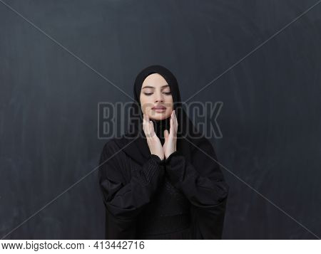 Portrait of young Muslim woman making dua