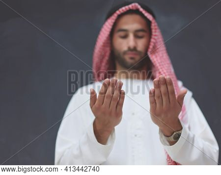 Arab man in traditional clothes praying to God or making dua