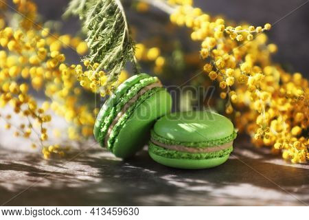 Couple Of Green Macaroons And Yellow Flowers