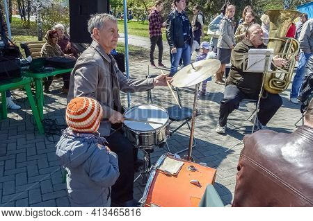 Chelyabinsk Russia May 09 2014 brass band performs in the recreation park. The boy looks at the drummer playing.