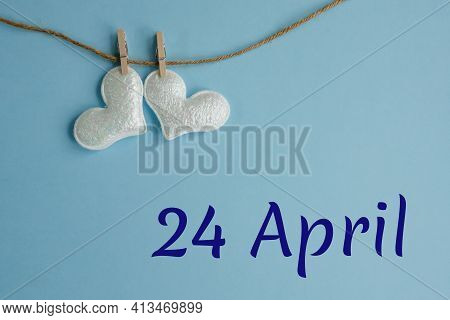 Commemorative Date April 24 On Blue Background With White Hearts With Clothespins, Flat Lay. Holiday