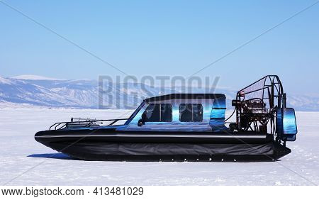 Hovercraft On Frozen Snowy Surface Of The Baikal Lake Near Cliffs Of Olkhon Island, Russia. Clear Wi