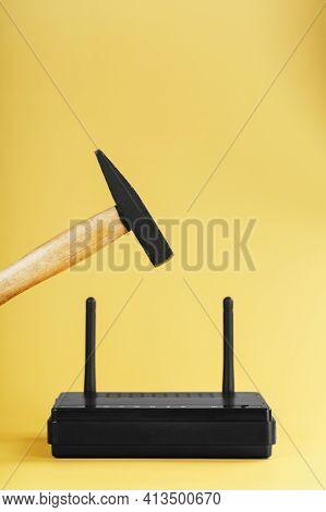 Hammer Over The Wi-fi Router For Destruction On A Yellow Background.