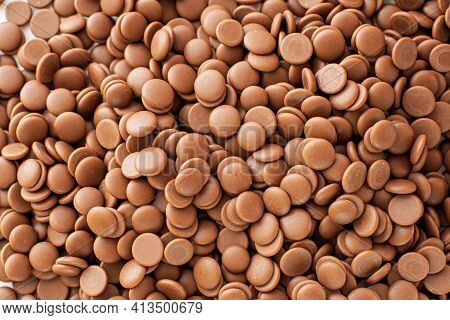 Chocolate Callets Background. The Concept Of Tempered Chocolate Confectionery. Cooking Chocolates By