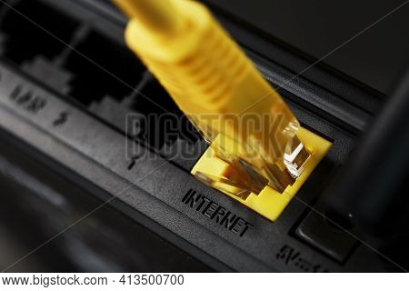 A Yellow Patch Cord Is Inserted Into The Wi-fi Port Of The Router To Access The Internet.