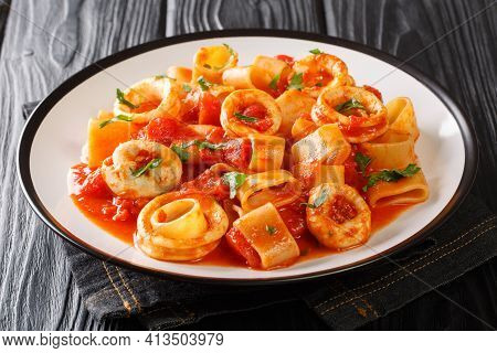 Portion Of Italian Calamarata Pasta With Squid Rings And Tomato Close-up In A Plate On The Table. Ho