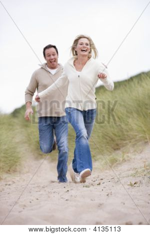Par kører på stranden smilende