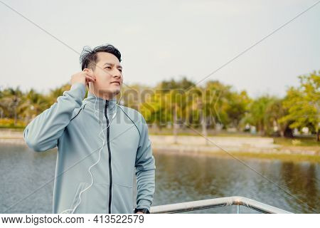 Young Sport Man Jogging And Listening Music In The Park.