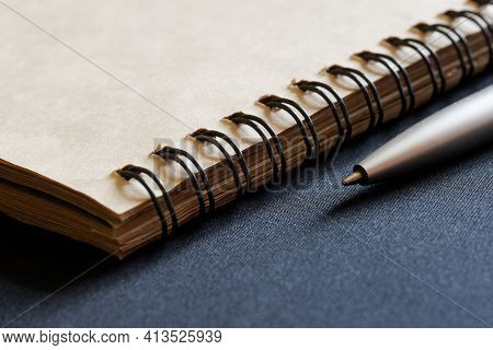 A Metalized Ballpoint Pen Rests Against A Dark, Fakery Background Next To An Eco-friendly Recycled N