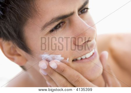 Mettere la crema da barba sorridente uomo