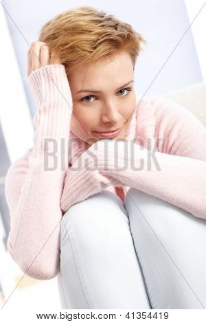 Sonriendo rodillas abrazando mujer atractiva, la mano en el cabello.