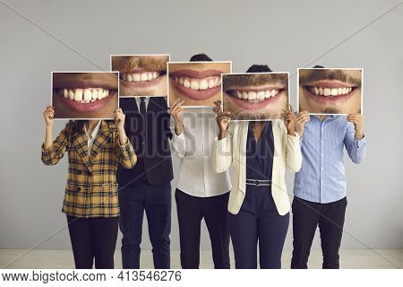 Group Of Diverse People Hiding Behind Big Funny Photos Of Happy Attractive Smiles