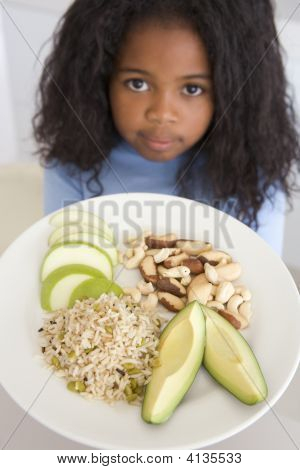 Giovane ragazza In cucina mangiare riso frutta e noci